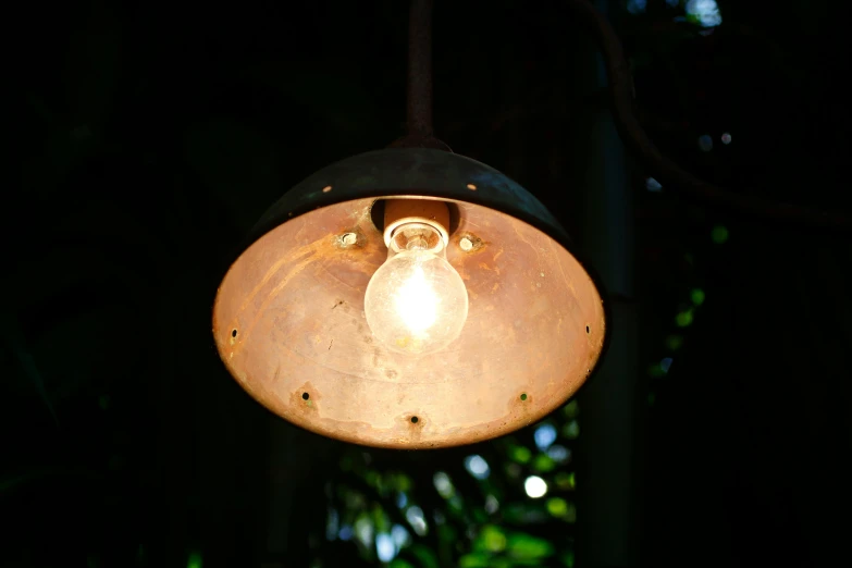 a close up of a light with a tree in the background, inspired by Brassaï, unsplash, morrocan lamp, well worn, cafe lighting, lit from above