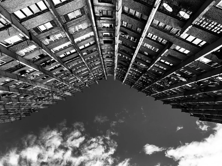 a black and white photo of a very tall building, by Patrick Pietropoli, unsplash, brutalism, hashima island, looking up into the sky, eyelevel!!! view!!! photography, photographic print