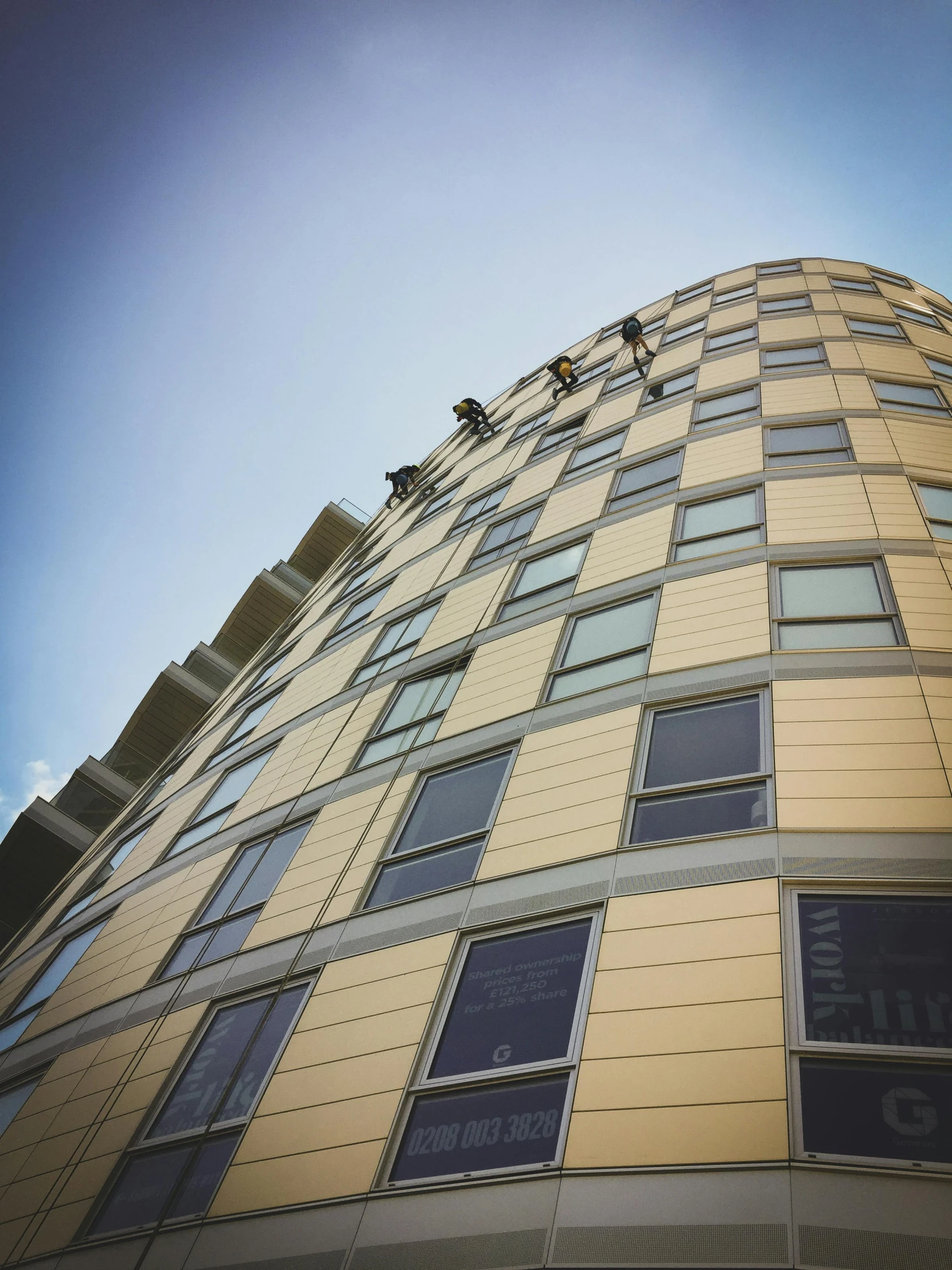 a tall yellow building with lots of windows, by Washington Allston, unsplash, bauhaus, people at work, worm\'s eye view, shot on iphone 6, balconies