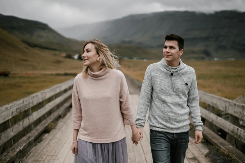 a man and a woman walking across a bridge, by Hallsteinn Sigurðsson, pexels contest winner, hurufiyya, wearing casual sweater, sweet looks, thumbnail, posed