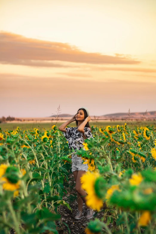 a woman standing in a field of sunflowers, a picture, by Julia Pishtar, pexels contest winner, happening, an australian summer landscape, various posed, covered in, early evening