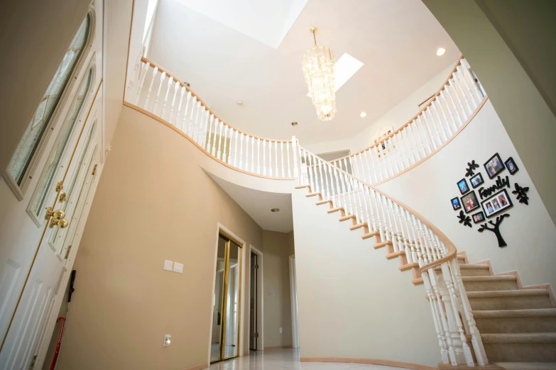 a staircase in a house with a clock on the wall, an album cover, by Ryan Pancoast, unsplash, light and space, white sweeping arches, vaughan ling, very wide angle view, paul kwon