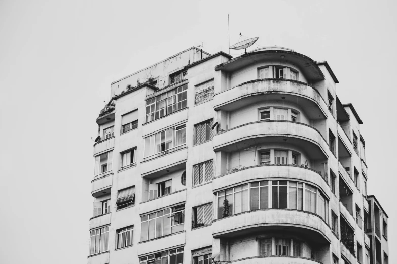 a black and white photo of a tall building, a black and white photo, by Emma Andijewska, unsplash, art nouveau, soviet apartment, nepali architecture buildings, rounded architecture, overpopulated