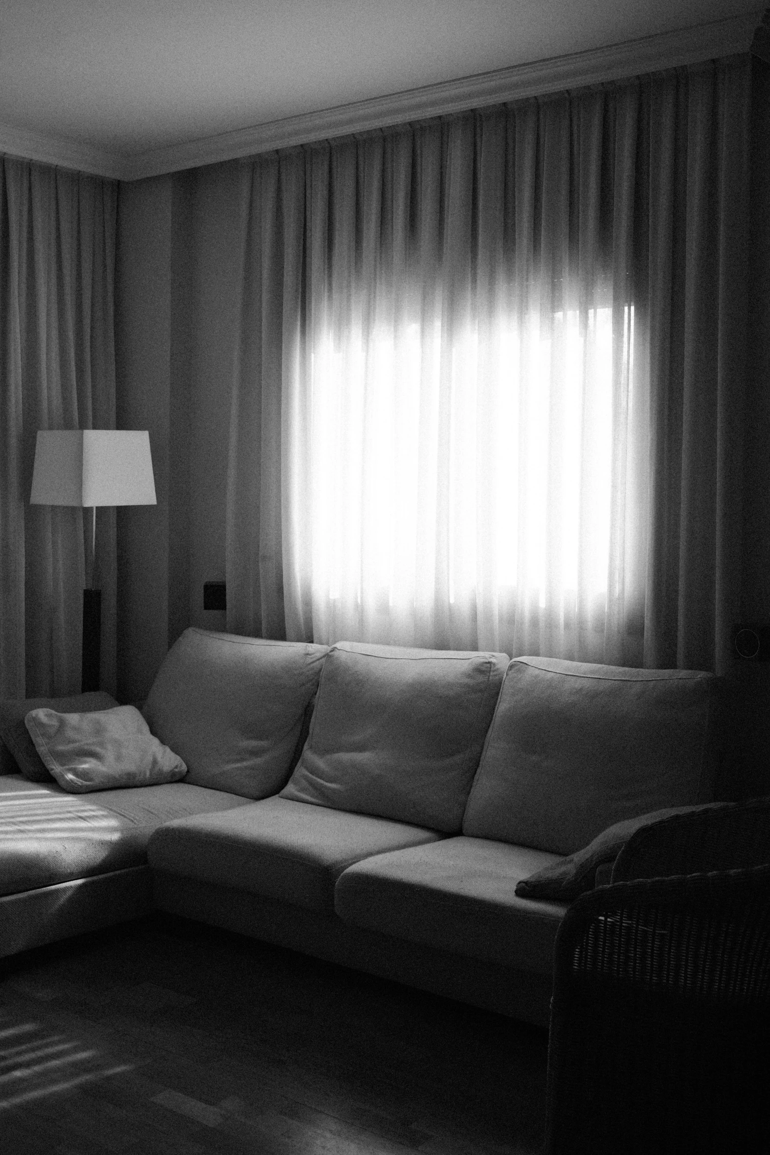 a black and white photo of a living room, inspired by Josep Rovira Soler, soft lighting album cover, curtains, morning atmosphere, sofa