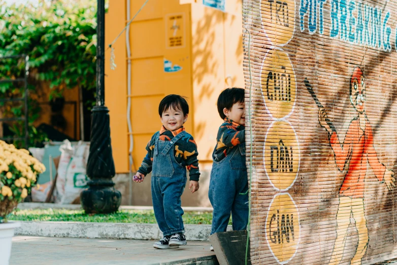 a couple of young boys standing next to each other, pexels contest winner, mai anh tran, 2 years old, yellow overall, 🚿🗝📝