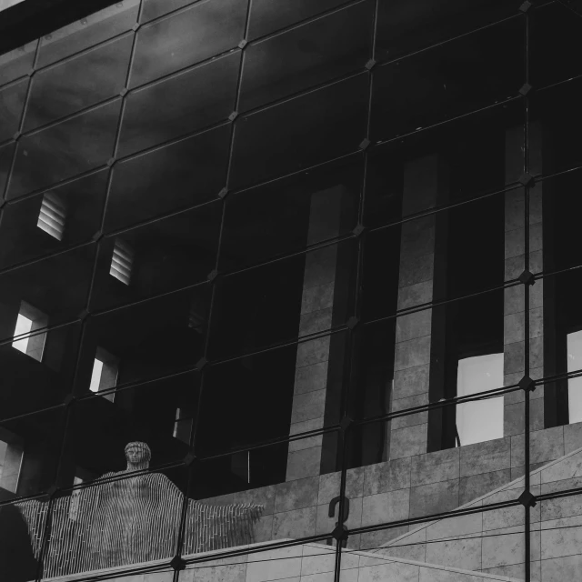 a black and white photo of a building, by Emma Andijewska, pexels contest winner, brutalism, window reflections, person in foreground, government archive photograph, high quality upload