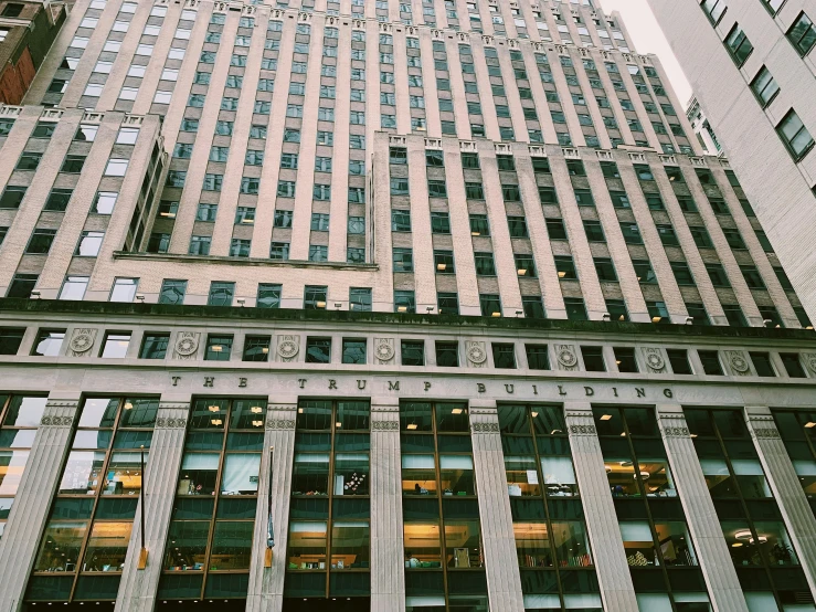 a tall building with a clock in front of it, by Adam Saks, unsplash, on madison avenue, 2000s photo, buildings carved out of stone, sephora