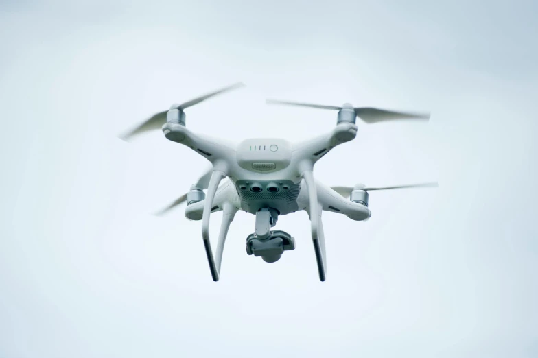 a large white drone flying through a cloudy sky, by Paul Bird, pexels, surveillance footage, high quality photo, electronics, islamic