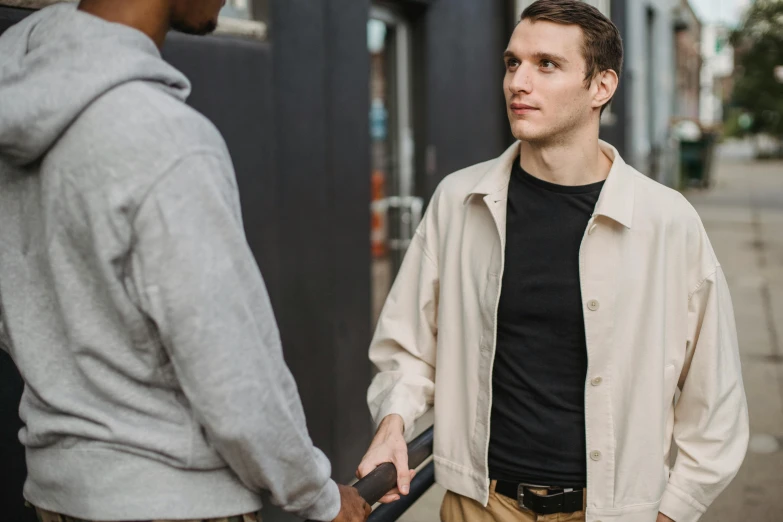 a couple of men standing next to each other, pexels contest winner, npc talking, street clothing, reaching out to each other, white male