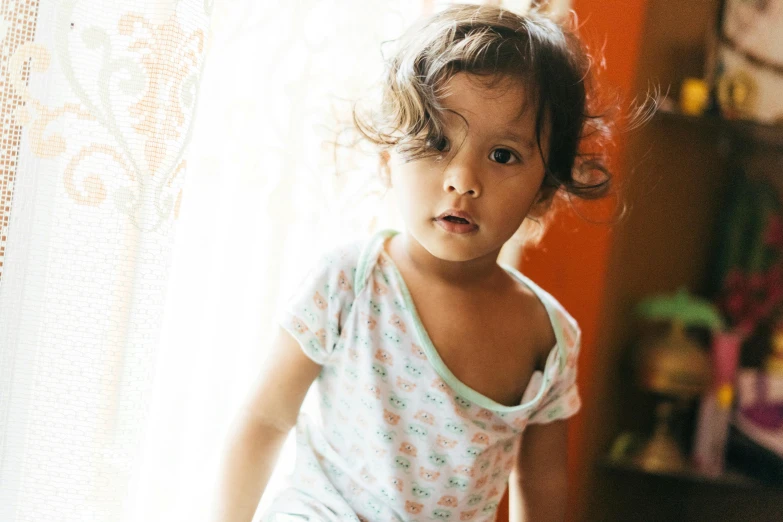 a little girl standing in front of a window, messy hair bedhead, alanis guillen, crawling towards the camera, lovingly looking at camera