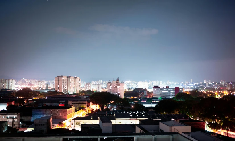 a view of a city at night from a rooftop, pexels contest winner, brutalism, henrique alvim corrêa, high resolution photograph, panoramic, white pale concrete city