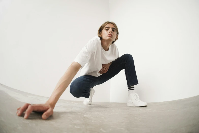 a person sitting on a skateboard in a room, trending on unsplash, hyperrealism, white shirt and jeans, man standing in defensive pose, on a white table, wearing adidas clothing