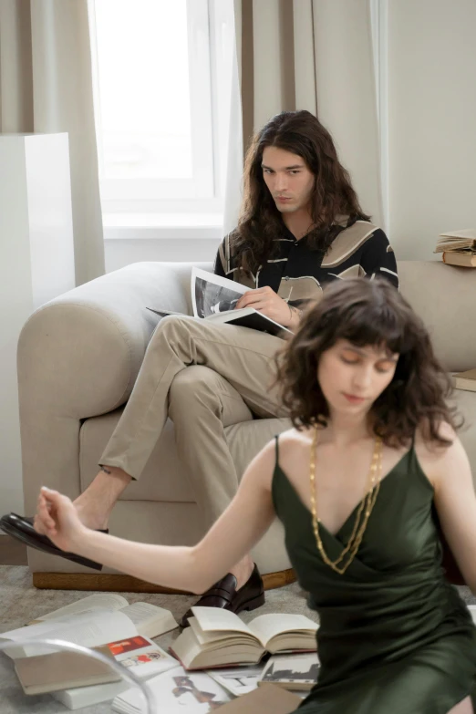 two women sitting on a couch in a living room, an album cover, by Nina Hamnett, trending on pexels, renaissance, young handsome pale roma, sitting on designer chair, wavy hair spread out, programming