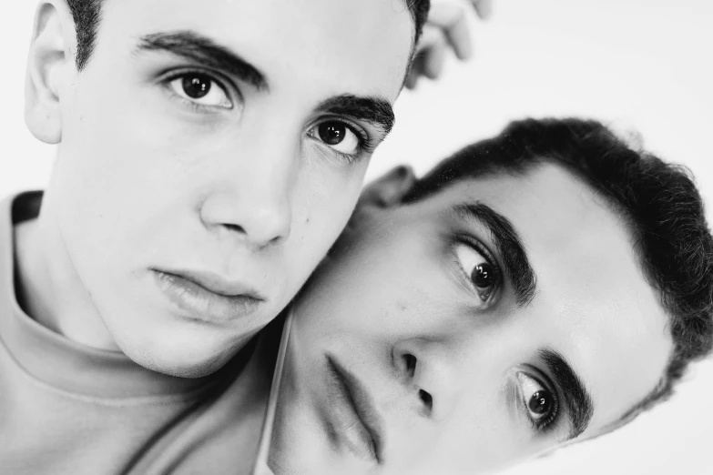 a couple of men standing next to each other, a black and white photo, by Maurycy Gottlieb, pexels, large eyebrows, yaoi, ariel perez, holding each other