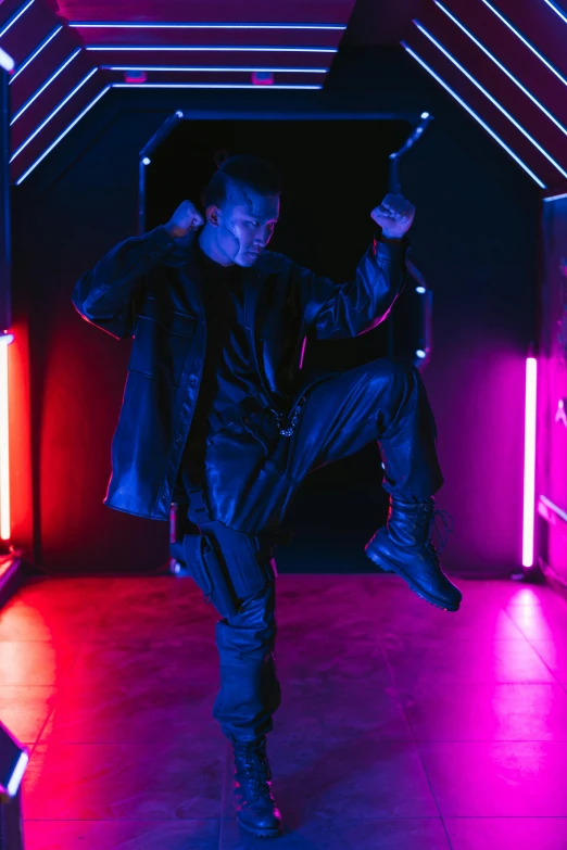 a man standing in a room with neon lights, combat stance, leather clothing and boots, instagram picture, action thriller