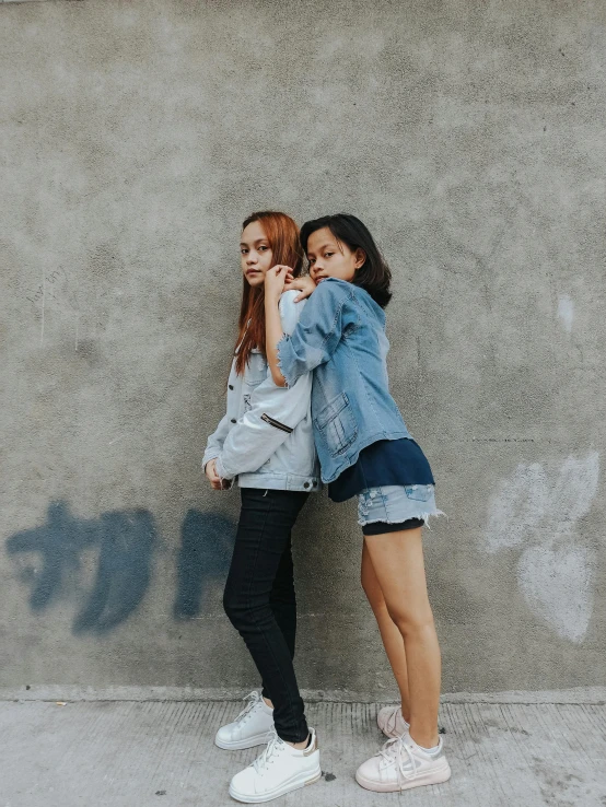 two women standing next to each other in front of a wall, trending on unsplash, denim jacket, 15081959 21121991 01012000 4k, asian girl, various pose