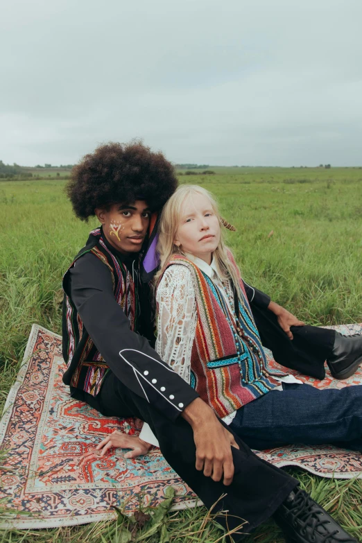 two people sitting on a rug in a field, an album cover, trending on unsplash, renaissance, jimi hendrix full body shot, albino skin, mixed race, at a fashion shoot