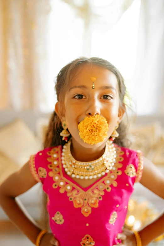 a little girl with a flower in her mouth, pexels contest winner, hurufiyya, intricate gold jewlery, yellow carpeted, professionally color graded, hindu aesthetic