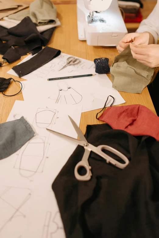 a woman sitting at a table in front of a sewing machine, flatlay, technical drawings, masks, inspect in inventory image