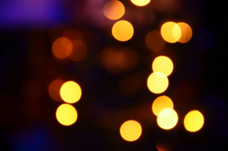 a close up of a cell phone in front of a christmas tree, by Niko Henrichon, pexels, light and space, orange and purple electricity, light circles, yellow light, deblurring