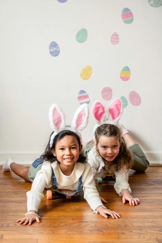 two little girls in bunny ears laying on the floor, by Ellen Gallagher, pexels contest winner, graffiti, translucent eggs, banner, product shot, holiday