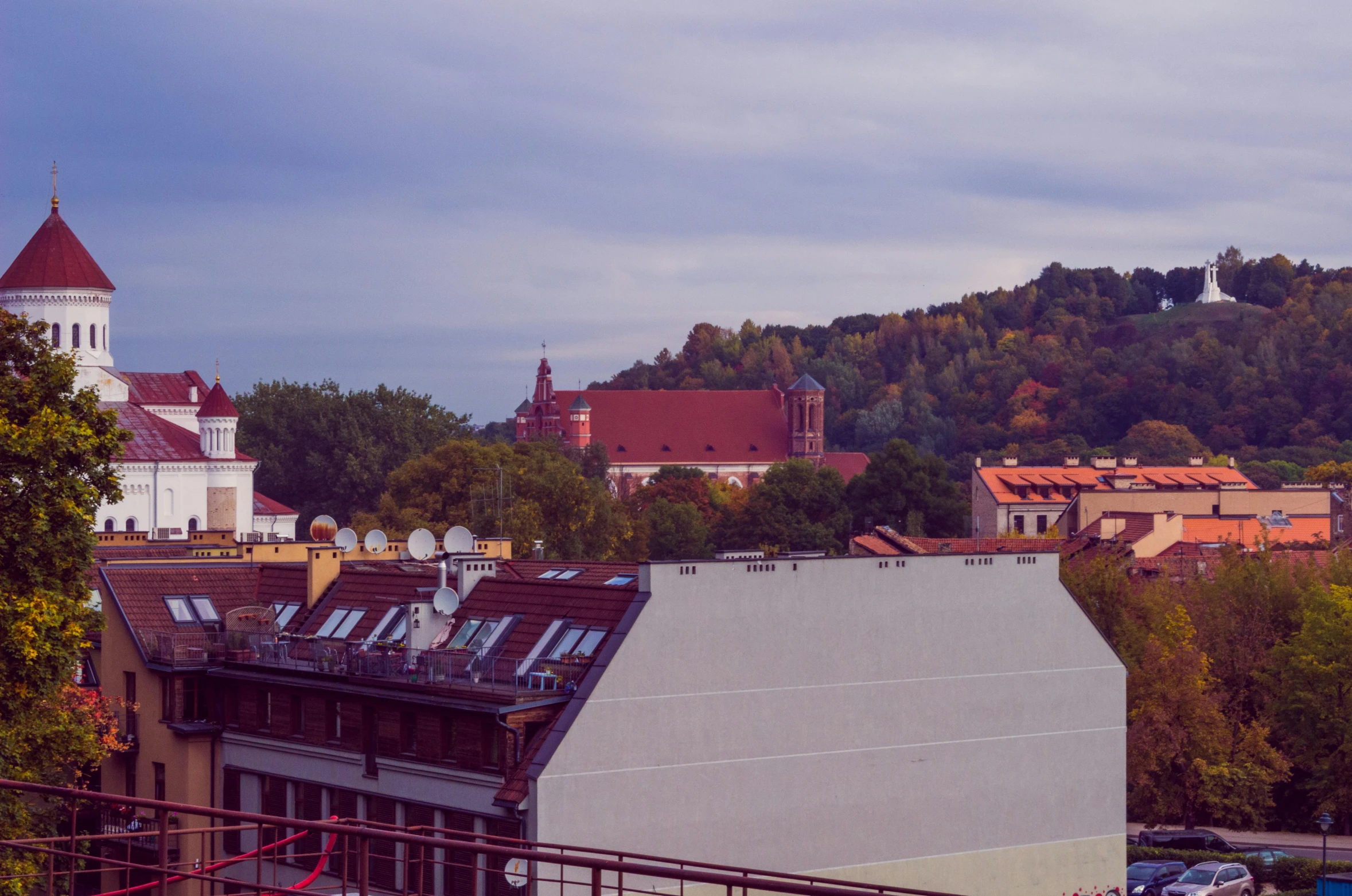 a large white building sitting on top of a lush green hillside, by Adam Marczyński, pexels contest winner, danube school, in legnica!!!, purple and scarlet colours, skyline view from a rooftop, terracotta