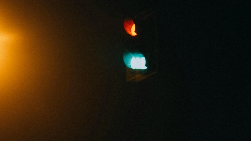 a traffic light on a foggy street at night, an album cover, inspired by Elsa Bleda, unsplash, postminimalism, teal orange, uneven glass apple in the dark, ignant, green and red