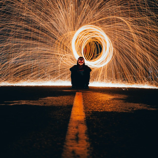 a person sitting on the ground in front of a fire, by Sebastian Spreng, pexels contest winner, glowing thing wires, stood in a tunnel, circle, firework