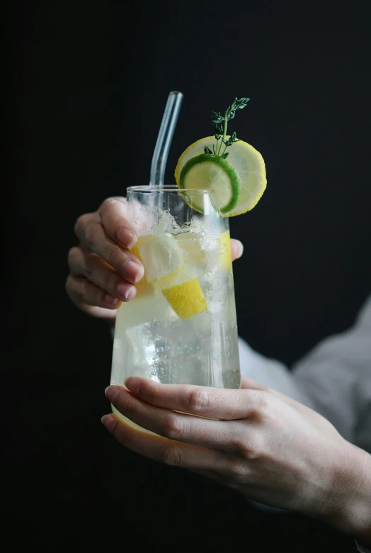 a woman holding a glass of lemonade, by Matthias Stom, pexels, renaissance, on a gray background, 🍸🍋, made of drink, zoomed in