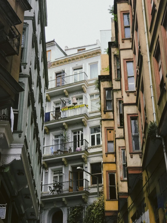 a couple of buildings that are next to each other, a photo, inspired by Niyazi Selimoglu, pexels contest winner, art nouveau, trending on vsco, balconies, ground - level view, low quality photo