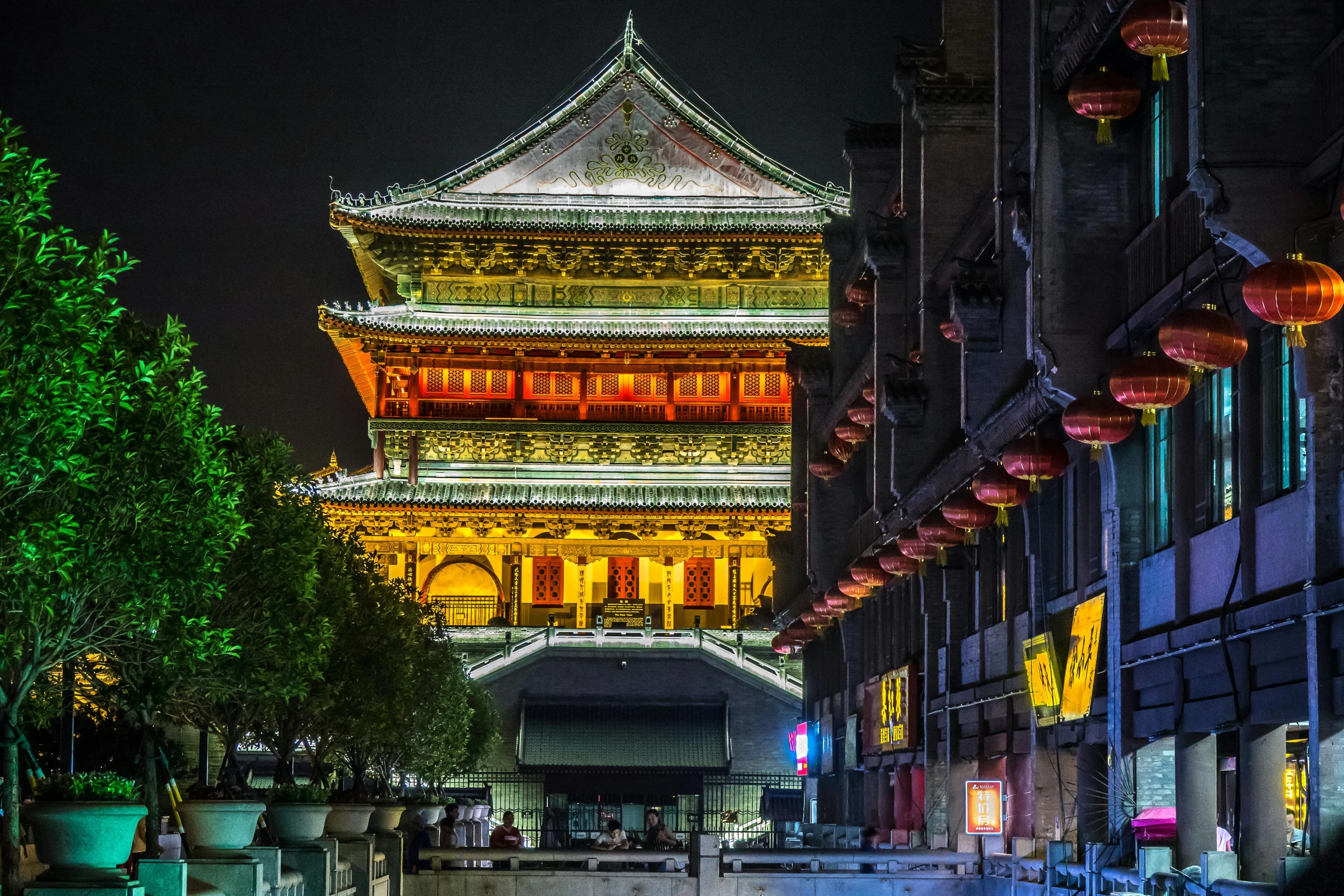 a tall building sitting on the side of a street, inspired by Wang Yi, pexels contest winner, art nouveau, glowing temple in the distance, yellow street lights, water temple, chengwei pan