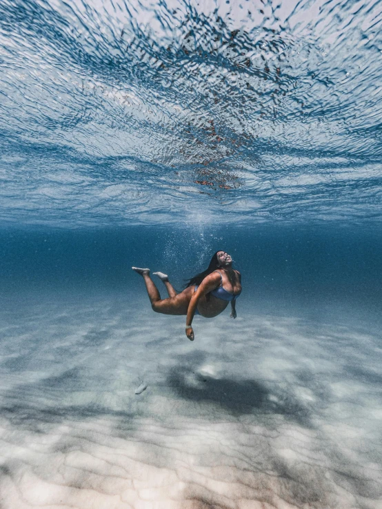 a woman in a bikini swims under the water, an album cover, inspired by Eric Zener, unsplash contest winner, trending on vsco, 500px photos, scuba diving, slightly tanned