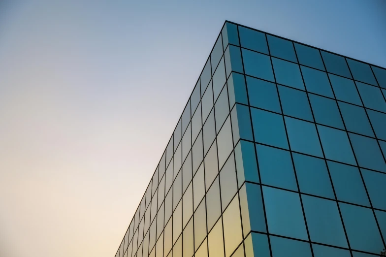 a tall glass building with a sky in the background, unsplash, square facial structure, soft light from the side, metal panels, corner office background