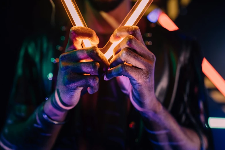 a close up of a person holding a pair of scissors, pexels contest winner, kinetic art, neon bar lights, holding wands, holding a wooden staff, led gaming