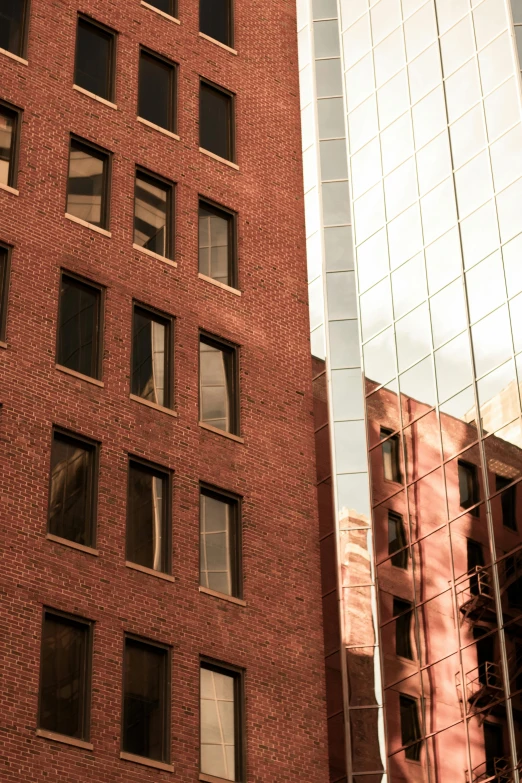 a couple of tall buildings next to each other, inspired by Thomas Struth, unsplash, brick building, brown, reflected light, boston