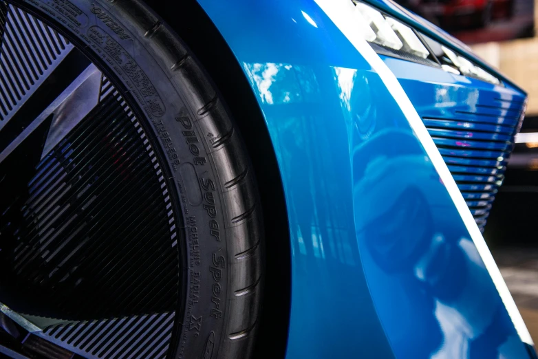 a close up of the front of a blue car, rim lght, aerodynamic, soft rubber, intricate detailing