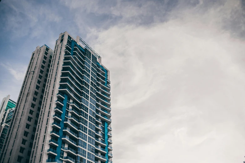 a couple of tall buildings sitting next to each other, unsplash, bauhaus, miami beach, multiple stories, blue hues, overcast