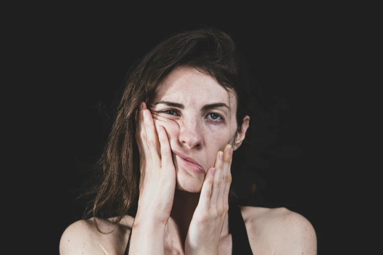 a woman covering her face with her hands, pexels contest winner, hyperrealism, tired face, with a black background, facial muscles, portrait photo of a backdrop