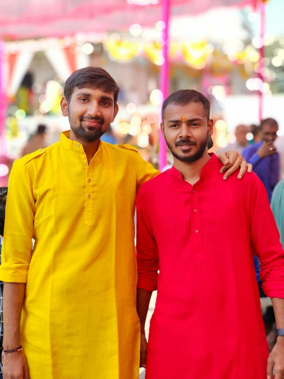 a couple of men standing next to each other, samikshavad, festive colors, wearing shirts, portrait image