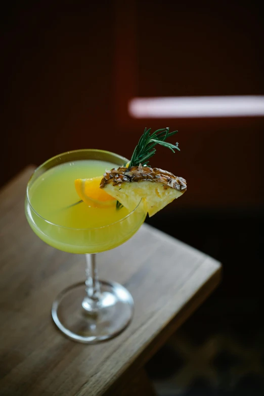 a cocktail sitting on top of a wooden table, yellow aureole, pine, f / 2 0, mantis