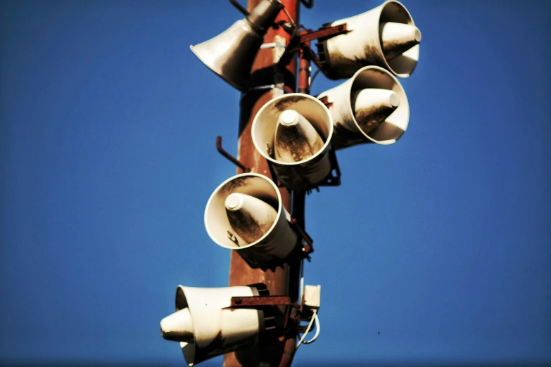 a couple of speakers sitting on top of a wooden pole, unsplash, tail lights, ((rust)), shouting, cone heads