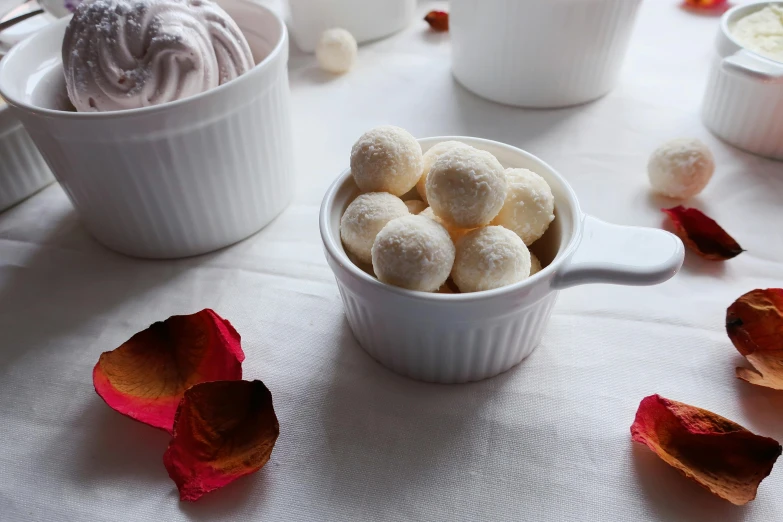 a close up of a bowl of food on a table, inspired by Ödön Márffy, cups and balls, large individual rose petals, vanilla, medium wide front shot