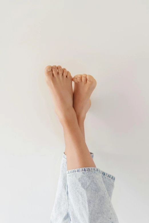 a person laying on a bed with their feet up, trending on pexels, arabesque, plain background, light tan, standing on two feet, detailed skin