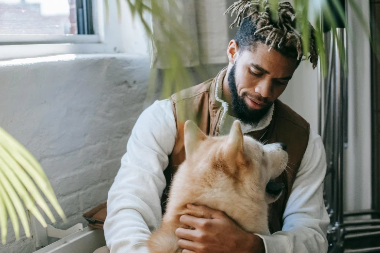 a man holding a dog in his arms, trending on pexels, renaissance, with afro, cozy environment, bowater charlie and brom gerald, furry wolf