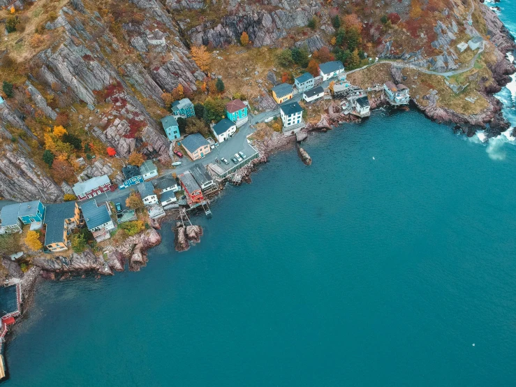 a large body of water next to a cliff, a tilt shift photo, by Jesper Knudsen, pexels contest winner, photorealism, waterfront houses, quebec, top down perspecrive, a cozy