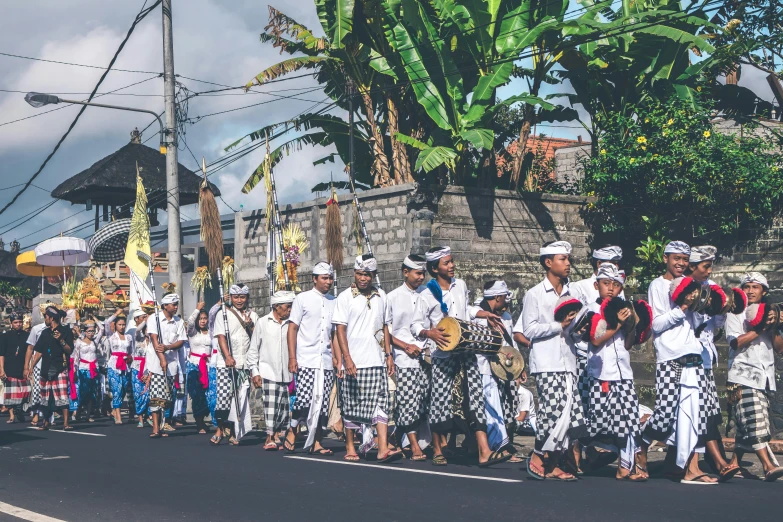 a group of people walking down a street, by Carey Morris, pexels contest winner, white sarong, traditional costume, background image, bali