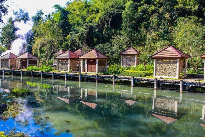 a row of cabins next to a body of water, sumatraism, avatar image