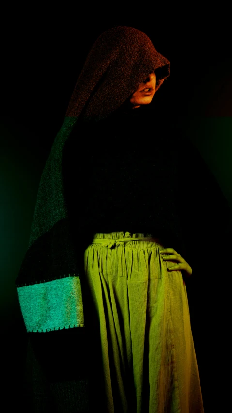 a person that is standing in the dark, an album cover, inspired by Georges de La Tour, unsplash, nun fashion model, black and green, hyper color photograph, brutalist fashion show