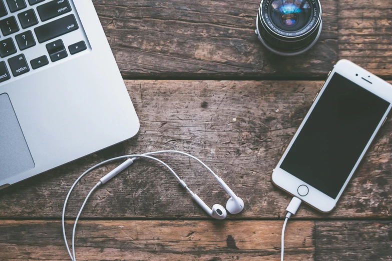 a laptop computer sitting on top of a wooden table, a picture, trending on pexels, earbuds, photo taken with an iphone, 9 9 designs, vintage electronics