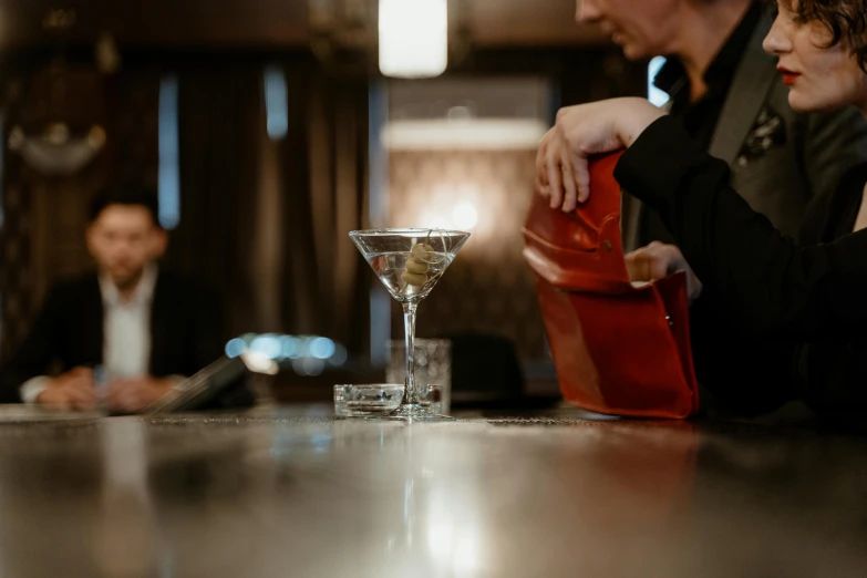 a group of people sitting at a bar, by Ndoc Martini, pexels contest winner, modern crystal martini glass, aussie baristas, half turned around, thumbnail